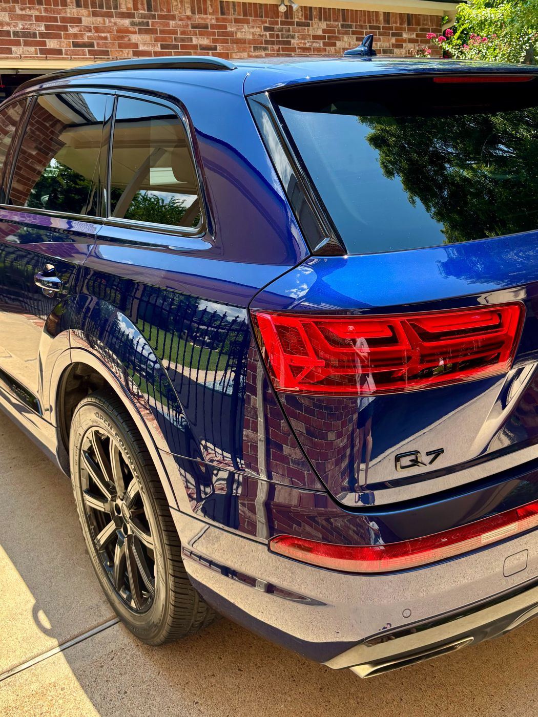 Rear quarter of a blue Audi Q7 with crisp reflections in the paint